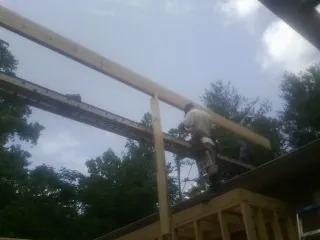 Carpenter setting a ridge beam over a new addition frame — Ice Dam Removal by Roofing Brothers in Gore