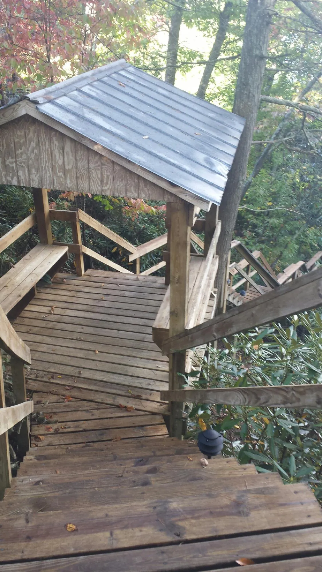 Metal roofed shelter over wooden steps on a wooded walkway — Skylight Repair & Installation work by our crew in Gore