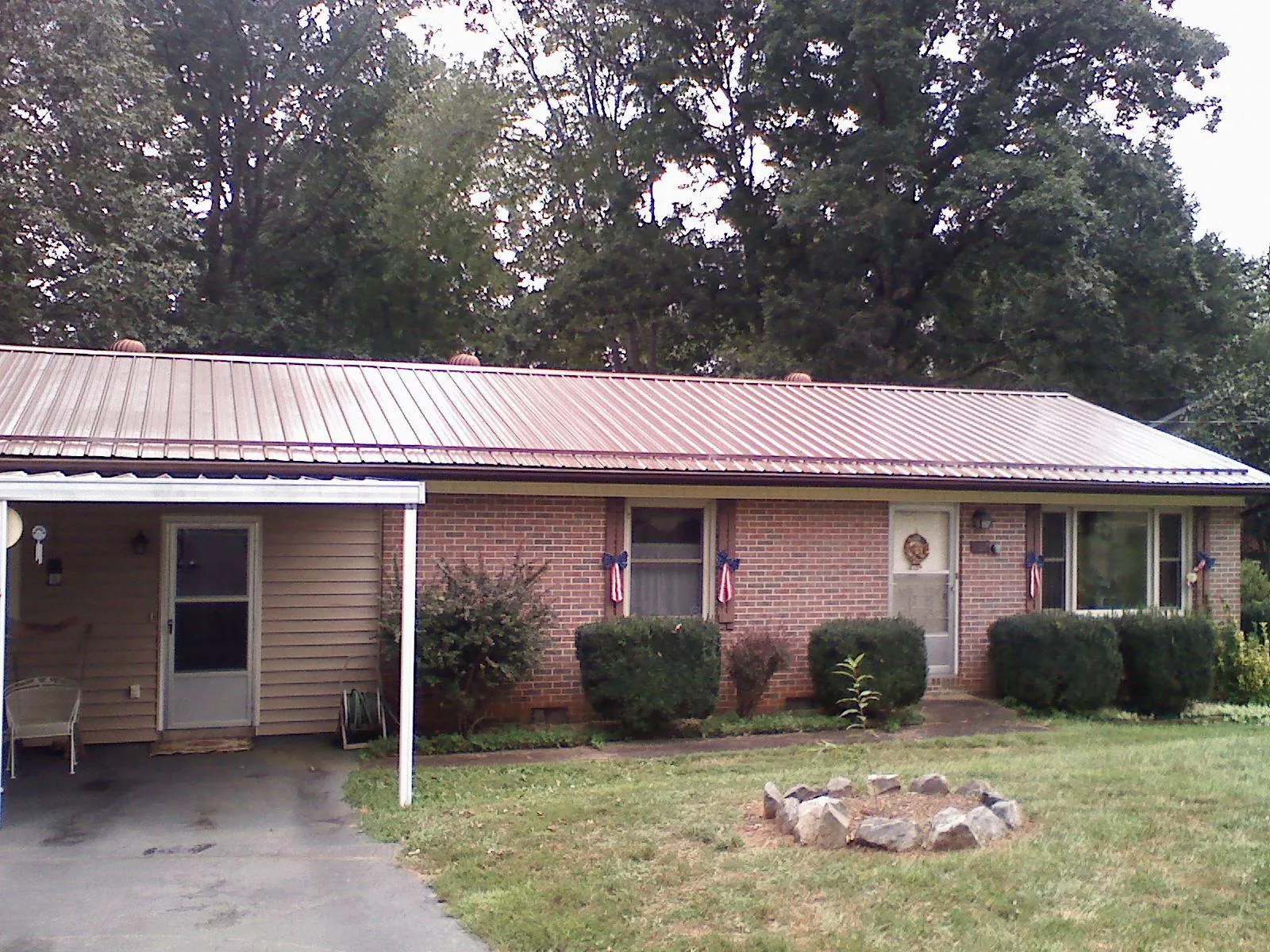 Bronze metal roof and carport on a brick ranch home — Roof Repair work by our crew in Gore